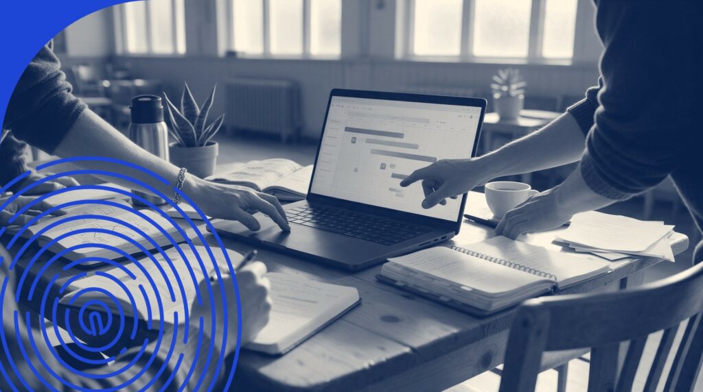 Mains autour d'un ordinateur portable et de cahiers sur une table de salle communautaire, lumière douce