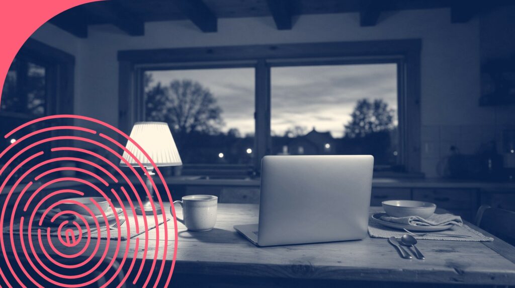 Bureau à domicile au crépuscule avec ordinateur portable, tasse et lampe allumée près d'une fenêtre